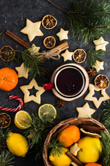 hot tea in a red mug in a new year's atmosphere. Christmas morning. A mug with a drink next to Christmas tree branches, oranges, spices and cookies