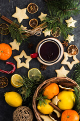 hot tea in a red mug in a new year's atmosphere. Christmas morning. A mug with a drink next to Christmas tree branches, oranges, spices and cookies