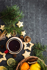 hot tea in a red mug in a new year's atmosphere. Christmas morning. A mug with a drink next to Christmas tree branches, oranges, spices and cookies