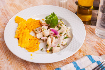Healthy ceviche of marinated cod fillet served with side dish of boiled corn seeds