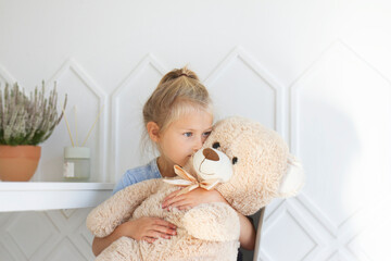 little girl playng with teddy bear