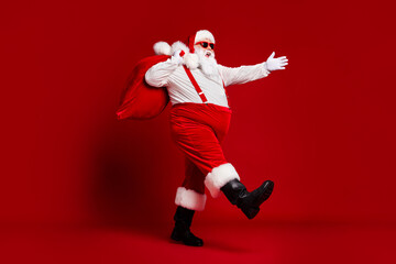 Full length body size view of his he attractive cheerful cheery funny fat Santa carrying big large...