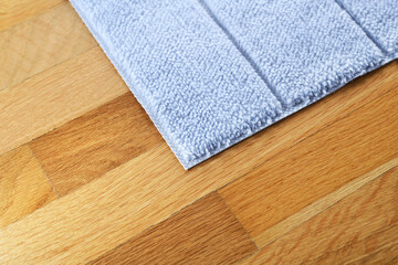 A bright blue foot mat rests on the parquet floor.