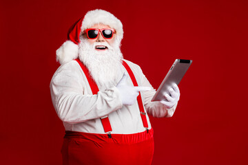 Fototapeta na wymiar Profile side view portrait of his he attractive cheerful cheery fat white-haired Santa demonstrating gadget ebook isolated bright vivid shine vibrant red burgundy maroon color background
