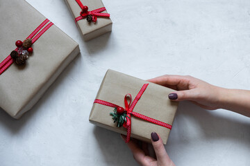 Hands hold a new year gift in craft paper