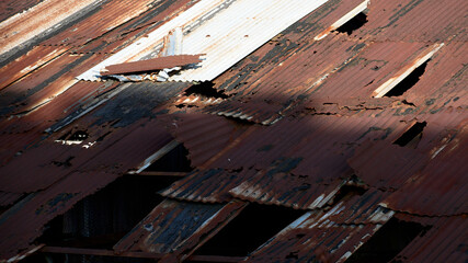 Sunlight shades on factory rusty damaged  tin roof top