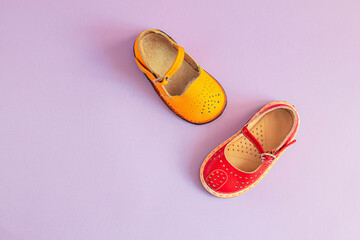 Stylish new yellow and red shoes on a colored pastel background with copyspace, top view, flat lay