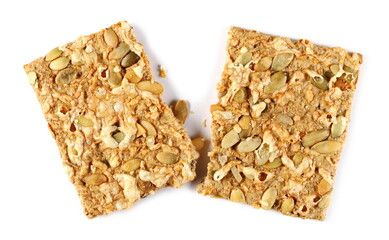 Crispbread with Gouda cheese and pumpkin seeds broken in half isolated on white background, top view