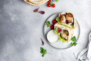 Meatballs in a pita with vegetable and yogurt sauce