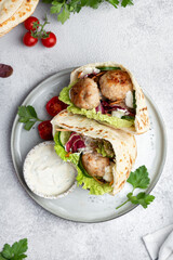 Meatballs in a pita with vegetable and yogurt sauce