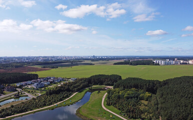 Top view of the river in the city park near the field and forest