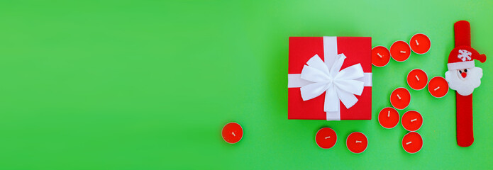 Christmas composition. Christmas gift, presrnt box and many red candles Top view. flat lay. banner