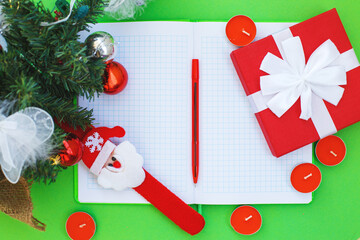 Christmas gift, presrnt box, many red candles, notepad for writing and fir tree branches with toys.