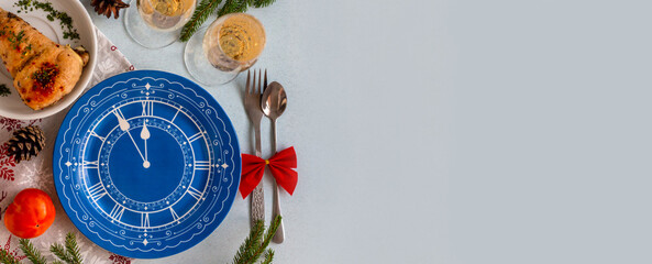 twelve o'clock on new year's eve concept, flat lay of christmas table, top view of empty blue plate with clock face decor, dishes and glasses of champagne, template or banner