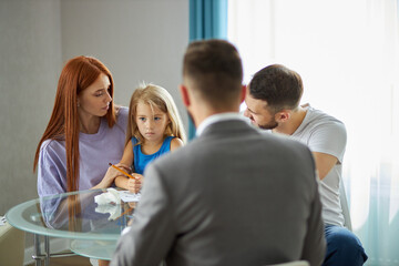 rear view on psychologist listening to family problems, they sit at table talking. children trauma due to divorce of parents