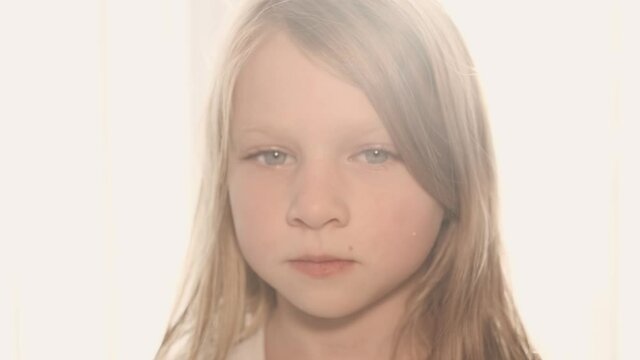 backlight and close up portrait of a serious caucasian girl looking in camera