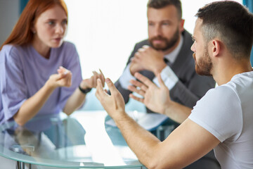 Fototapeta premium young caucasian male psychologist in suit listen to couple quarreling, try to help. support, help, therapy, consultation