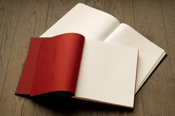 Open book on wooden table with red and white empty pages. Booklet, magazine mock up for any design or advertising 