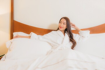 Portrait beautiful young asian woman smile relax on bed in bedroom interior