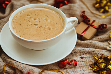 Coffee on a background of knitted fabric with gifts and holiday bows.Hot winter drink. Cocoa and cappuccino.