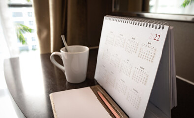 Calendar 2022 schedule with blank note for to do list on wooden desk	
