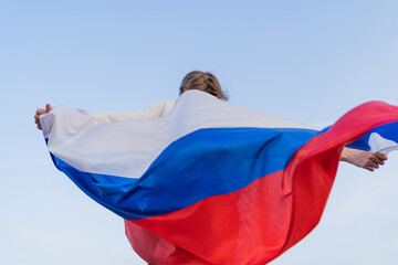 A happy Russian woman whirls with the Russian flag. Independence Day of the Russian Federation