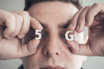 White letters 5G in closed eyes. Man faced to danger of harmful for health radiation of new...