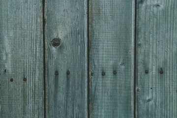 Tablas de madera antiguas de una valla exterior desgastada y rugosa. Primer plano de madera con nudos y dañada por el paso del tiempo.