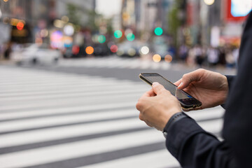 渋谷でスマホを操作する若い男性の手元