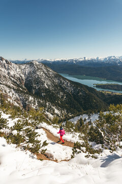 Wanderin im Neuschnee auf dem Gratweg zwischen Heimgarten und Herzogstand mit Blick auf den Walchensee