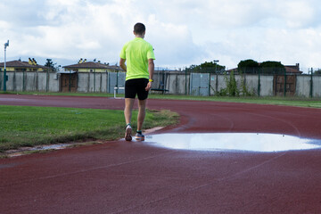 A man walking on the running track.