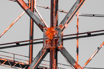 Old gas structure in dangerous area. Details of joints and rivets under a warm sunset, orange...