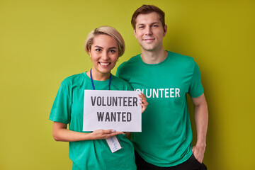 two caucasian man and woman waiting for new people in their charity organization, they hold paper...