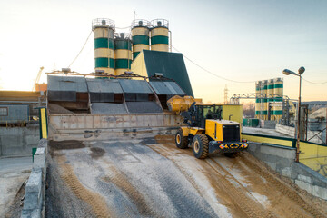 A wheel loader loads sand into a silo.