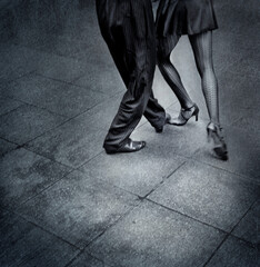 Creative B&W film shot of two tango dancers in the street. Visible grain film grain