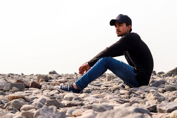 Fototapeta na wymiar Young indian man standing on rocks