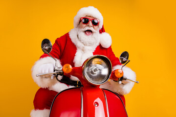 Portrait of his he nice funny cheerful cheery cool hipster Santa riding moped fast speed travel...