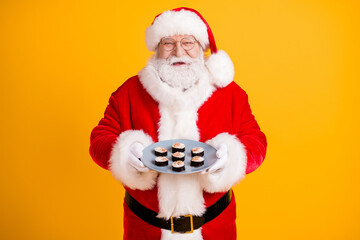 Fototapeta na wymiar Portrait of his he nice cheerful cheery funny glad white-haired Santa holding in hands homemade domestic fresh tasty yummy sushi meal isolated bright vivid shine vibrant yellow color background