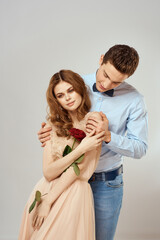 Young couple romance hug relationship dating red rose light studio background