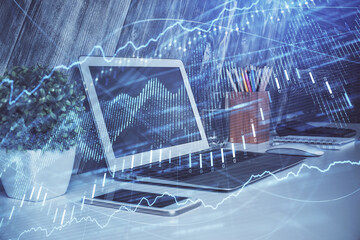 Double exposure of chart and financial info and work space with computer background. Concept of international online trading.
