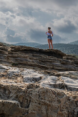 Ragazza sulla vetta guarda giù il panorama