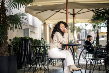 Young woman is drinking coffee sitting in a bar