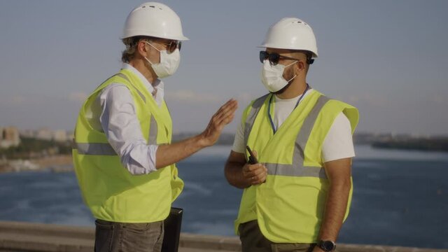Contactors in masks talking on construction site