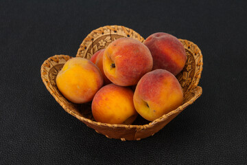 Fototapeta na wymiar Peach heap in the wooden basket
