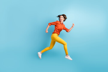 Fototapeta na wymiar Full size profile photo of attractive funny lady rushing shopping center sale discount runaway want come first early morning wear orange shirt trousers sneakers isolated blue color background