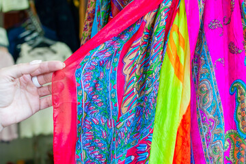 hand of a woman choosing a product on a hanger in a store