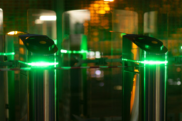 Night scene with two turnstiles with green led lighting without people at the station
