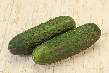 Green fresh cucumbers over background