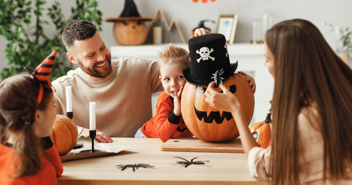 Happy family decorates the house, getting ready for the Halloween celebration.