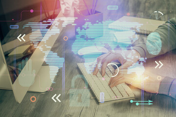 Double exposure of world map hologram with man working on computer on background. Concept of...
